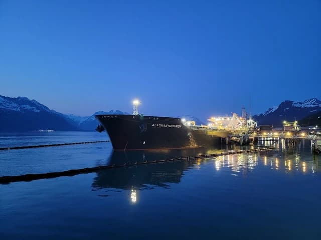 Oil tanker MT Alaskan Navigator docked at Valdez Marine Terminal, with mountains in background.