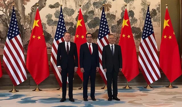Steven Mnuchin, Robert Lighthizer, and Liu He standing with flags of the US and China.