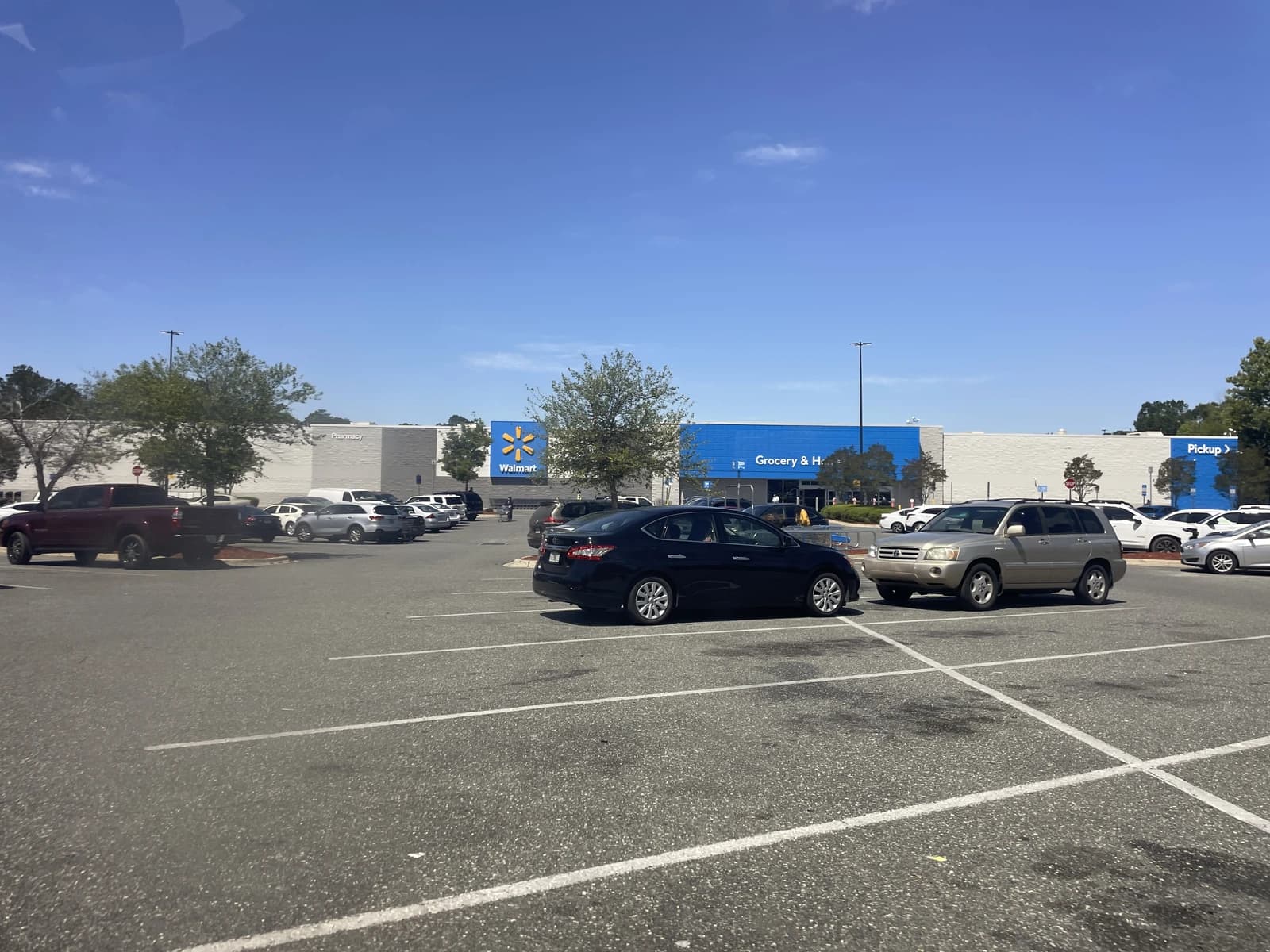Exterior of a Walmart Supercenter in Quincy, Florida, with a parking lot full of cars.