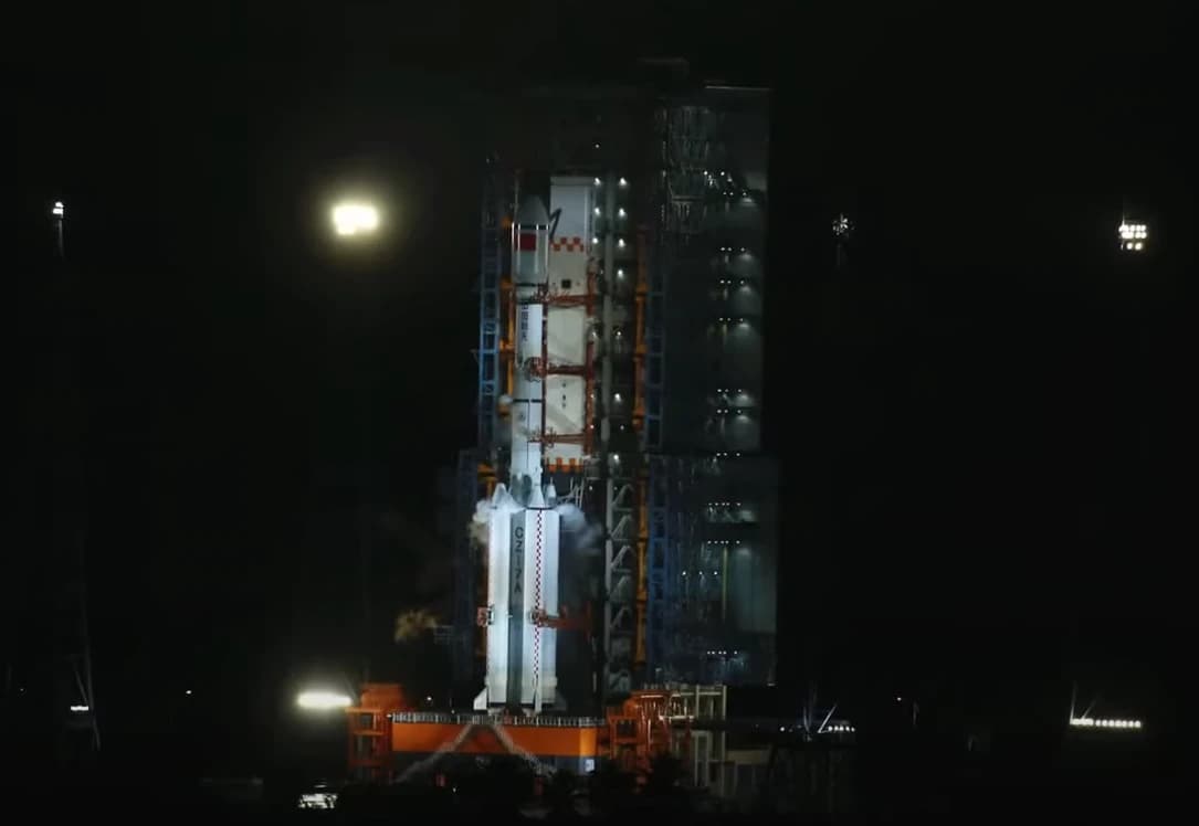 Chinese Long March 7A rocket stands on a launchpad at night.