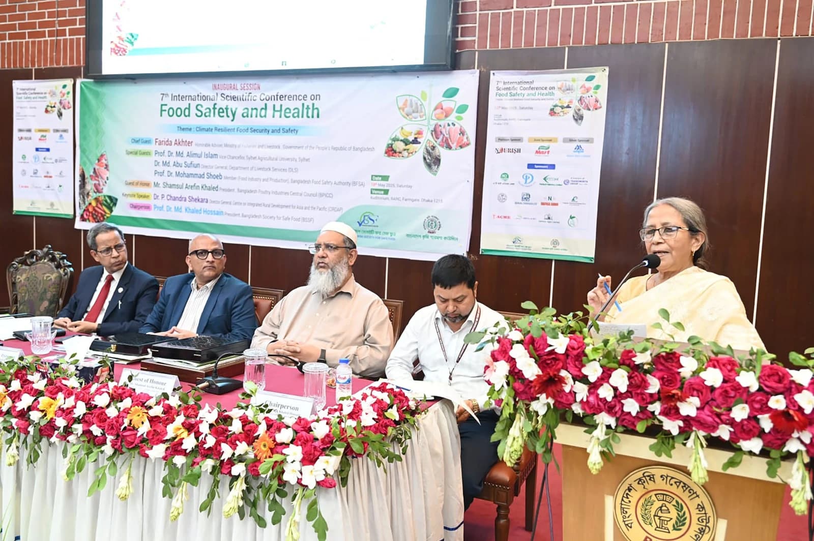 Woman with eyeglasses speaking at a podium during the 7th International Scientific Conference on Food Safety.