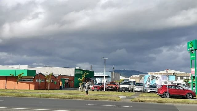 Woolworths supermarket building at Andersons Bay with cars parked in the front.