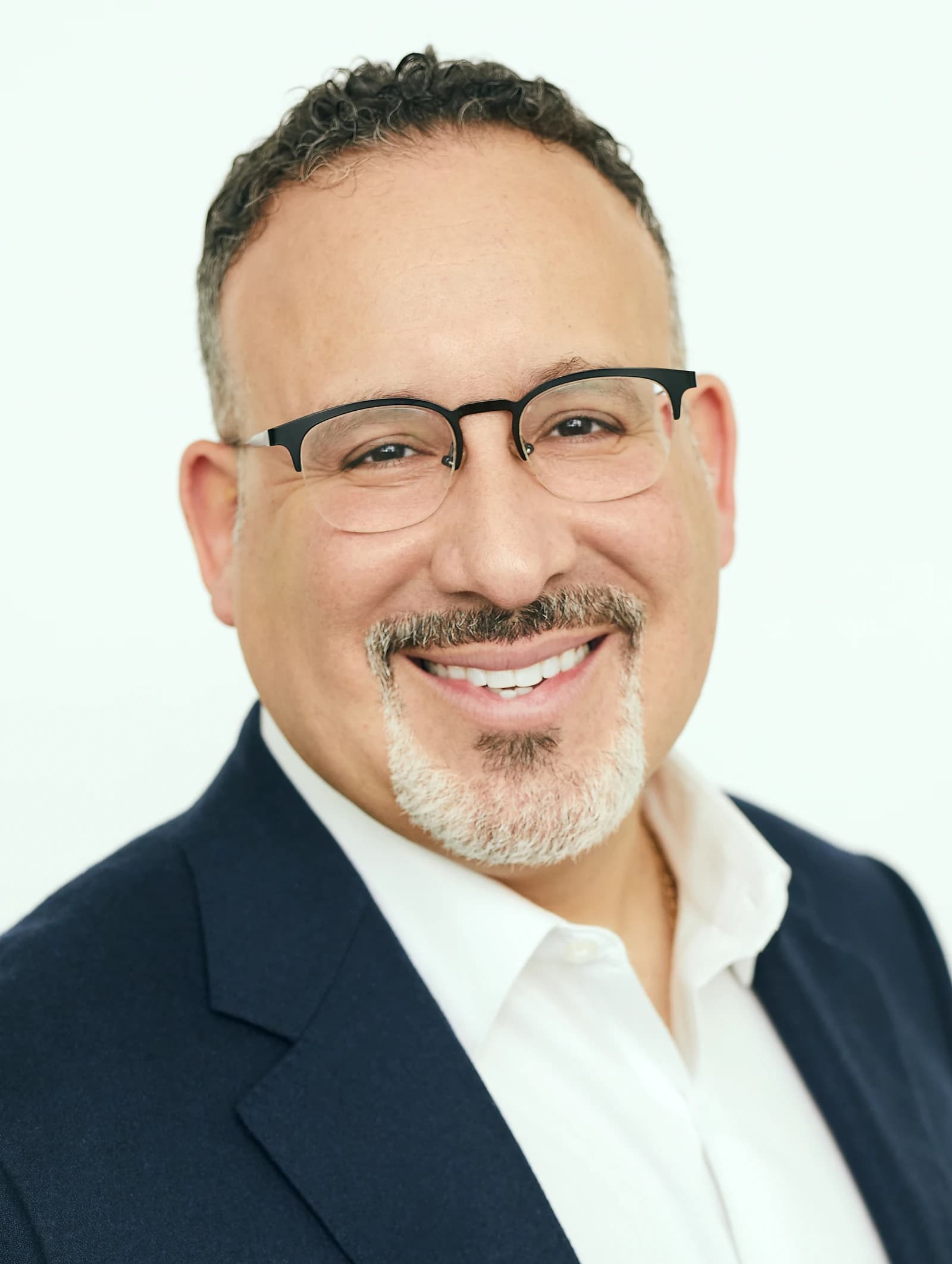 Miguel Cardona, U.S. Secretary of Education, smiling and looking directly at the camera.