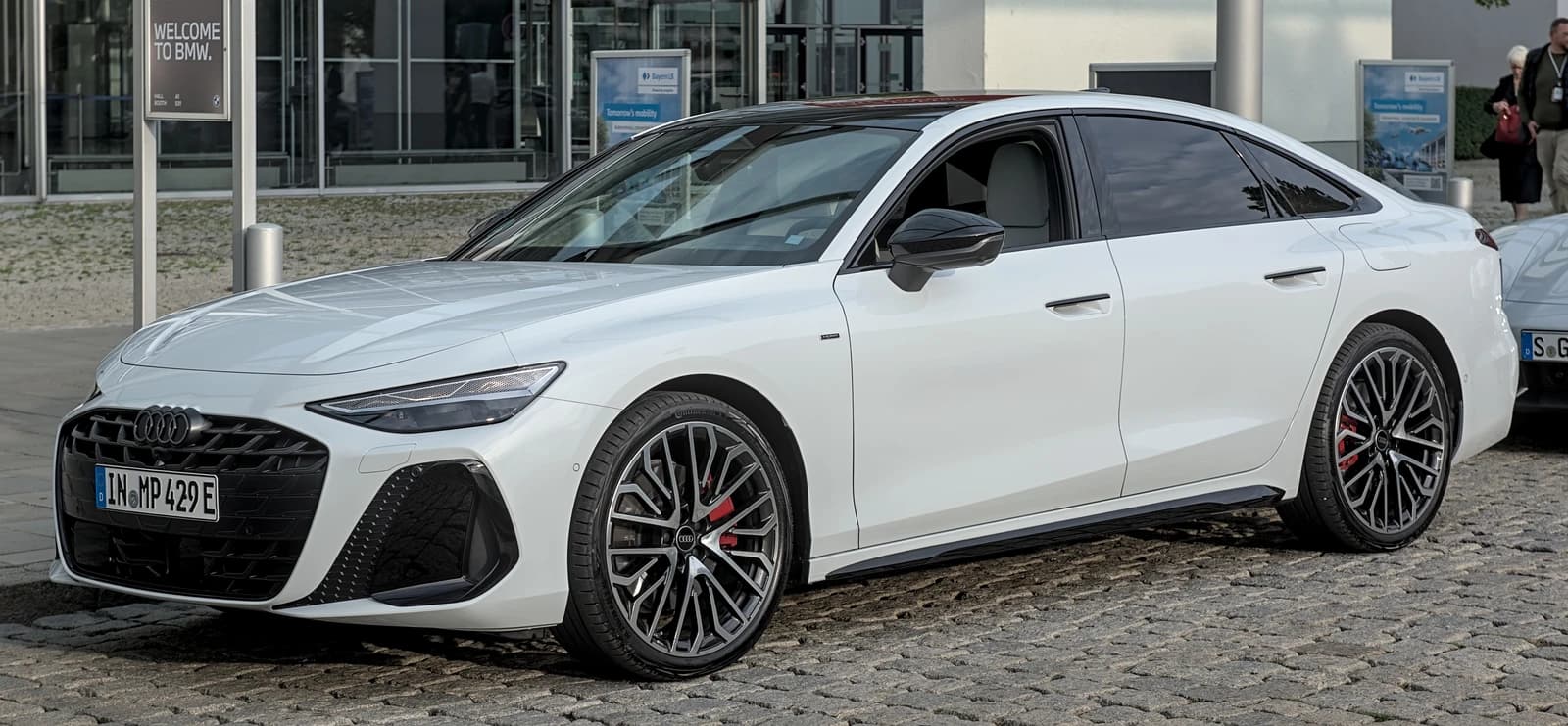 White Audi A6 C9 sedan on a paved surface outside a building.