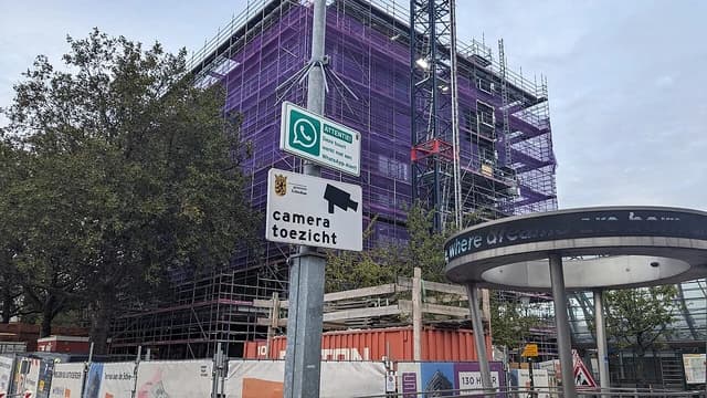 Warning signs for WhatsApp alerts and security cameras in Schiedam, Netherlands.