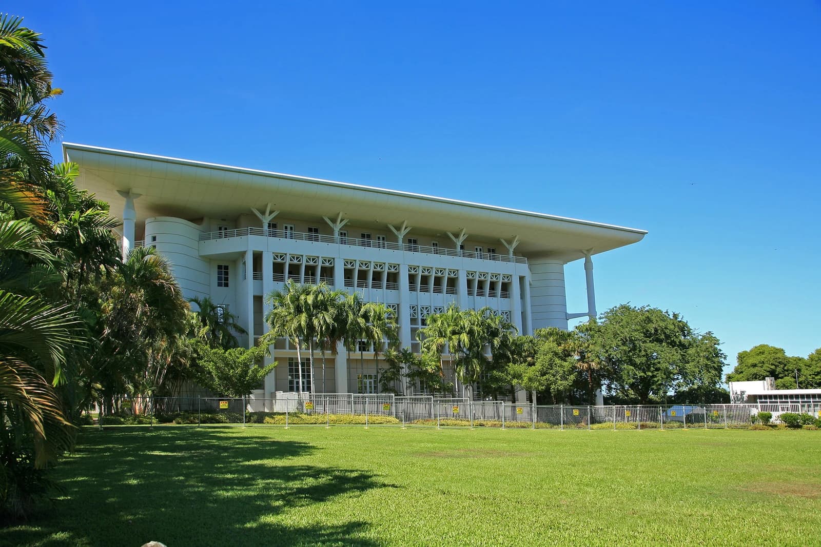 Parliament House building in Darwin, Northern Territory, under a clear blue sky.