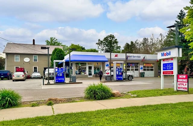 Exterior of a Mobil gas station in Shelburne, Vermont, showing gas pumps and price sign.