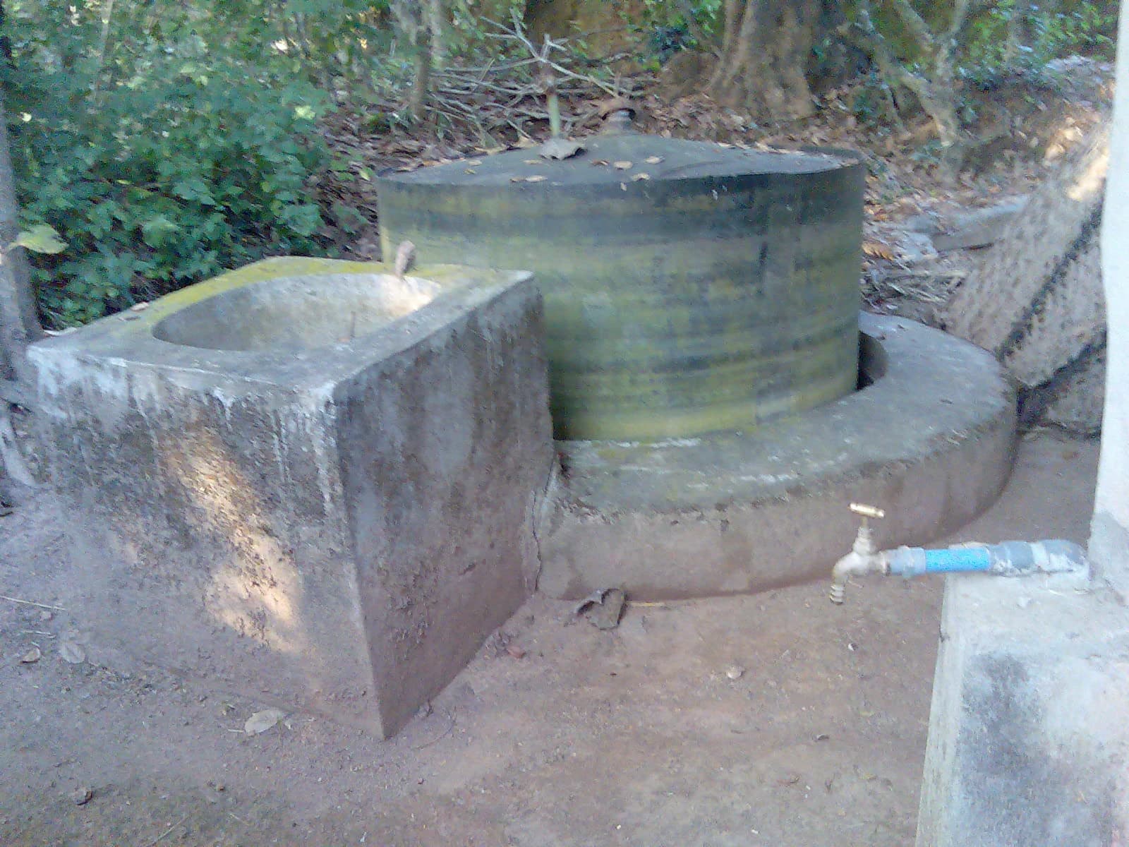 Small-scale gobar gas plant with a fermentation tank and input well.
