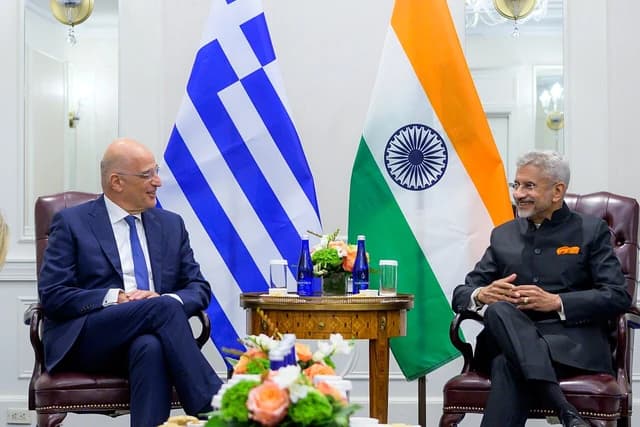 S. Jaishankar, India's External Affairs Minister, sits in an armchair smiling with the Indian flag behind him.