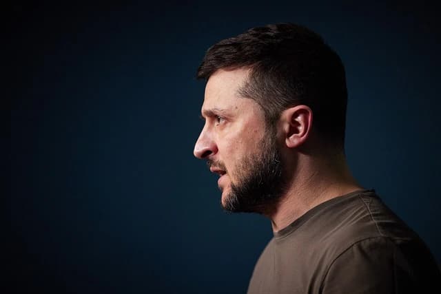 Ukrainian President Volodymyr Zelenskyy speaks in profile with his mouth slightly open.
